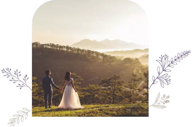 Couple holding hands on their wedding day, overlooking mountains in the distance